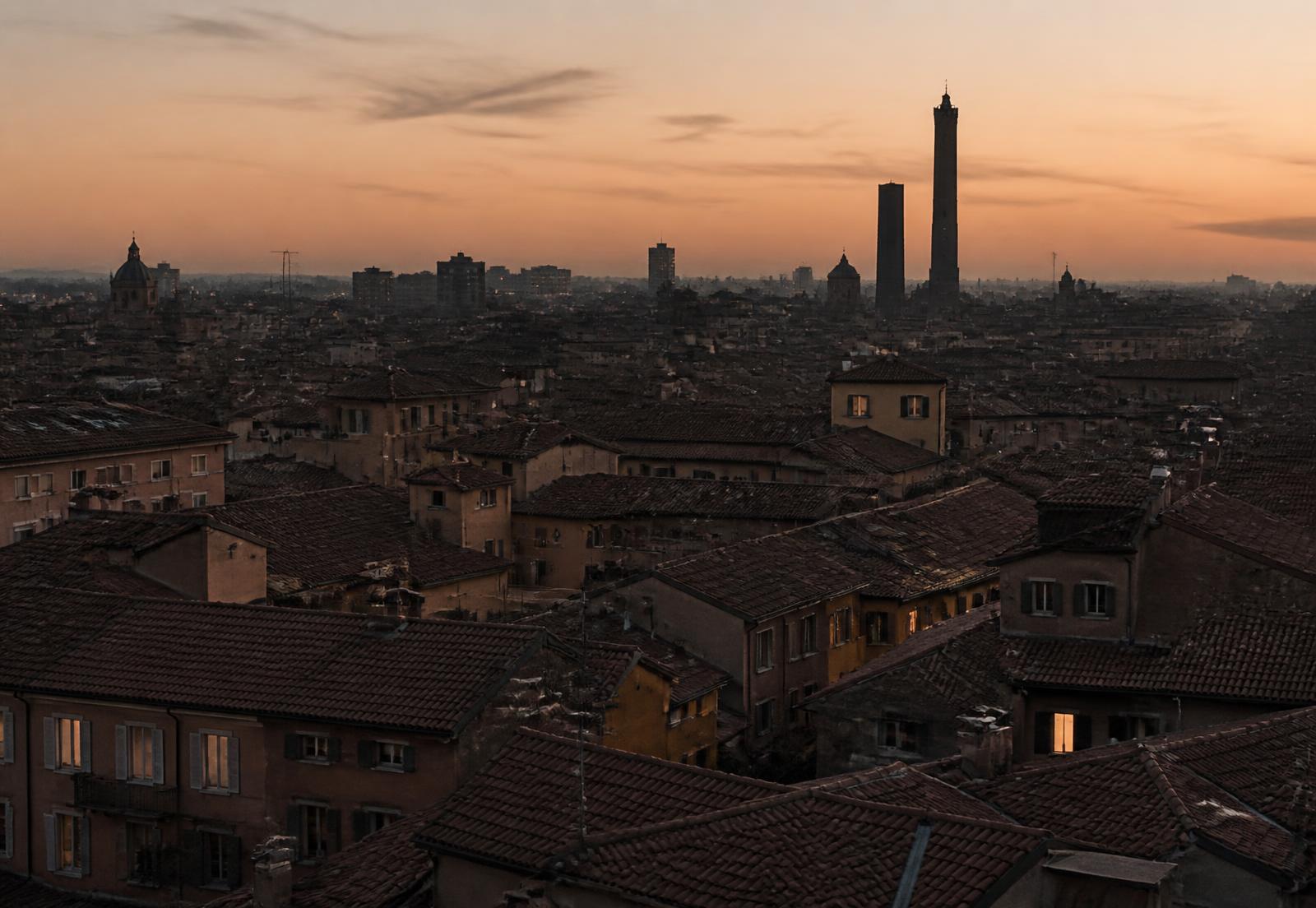 I tetti di Bologna al tramonto con le Due Torri all'orizzonte